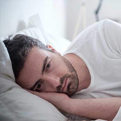 Sleep deprived man in bed